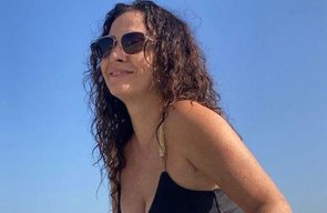 Claudia Ohana aproveita dia de sol na praia e posa com maiô